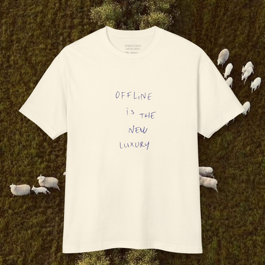 white cotton t-shirt with quote 'offline is the new luxury' raw minimalist t-shirt unisex style on a natural background landscape with sheeps trend 2026 tee