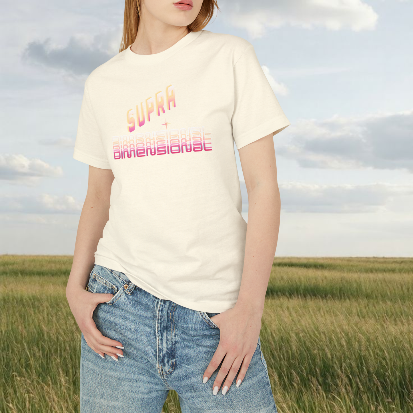 spiritual t-shirt, a female model wear a jean and a white cream t-shirt printed in pink " SUPRA DIMENSIONAL" she is standing in nature environement 
