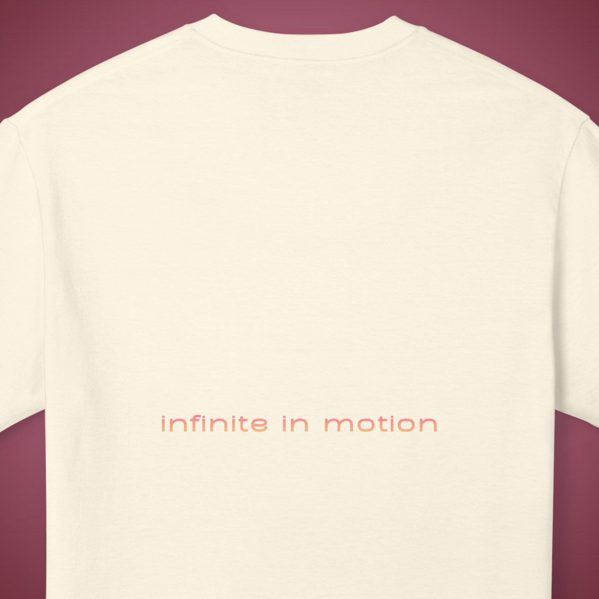 white cream t-shirt back view with the text printed in the middle "infinite in motion" in beige and pink soft colors minimalist style. spiritual innovative brand